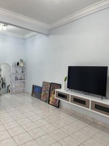 ein Wohnzimmer mit einem Flachbild-TV auf einem Entertainment-Center in der Unterkunft 3Homestay Bentong in Bentong