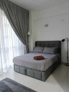 a bed in a bedroom with a large window at Studio 14 Vacation with Pool in Shah Alam City in Shah Alam