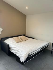 a bedroom with a large bed with white sheets at gîte Lemarocha in Groffliers