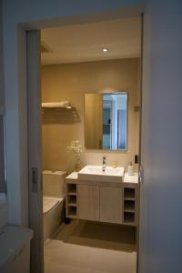 La salle de bains est pourvue d'un lavabo, d'une baignoire et d'un miroir. dans l'établissement Modern 2-bedroom Apartments Garden view in Skypark Laguna Bang Tao, à Bang Tao Beach
