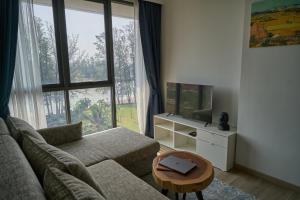 a living room with a couch and a tv and a table at Modern 2-bedroom Apartments Garden view in Skypark Laguna Bang Tao in Bang Tao Beach