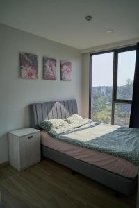 邦濤海灘的住宿－Modern 2-bedroom Apartments Garden view in Skypark Laguna Bang Tao，一间卧室设有一张床和一个大窗户