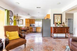 a kitchen and living room with a couch and a refrigerator at Desert Sun Flower: Private Spa, pool, Golf area in Coachella