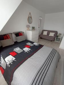 1 dormitorio con 1 cama con manta blanca y negra en Charmant duplex, bord de mer, en Merville-Franceville-Plage