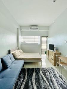 a living room with a blue couch and a rug at WV 5 Peaceful Abode in Iloilo City