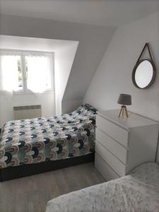 1 dormitorio con 1 cama con tocador y espejo en Charmant duplex, bord de mer, en Merville-Franceville-Plage