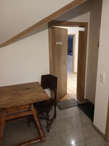 einen Holztisch und einen Stuhl in einem Zimmer in der Unterkunft Wohnung Staufenblick in Freilassing