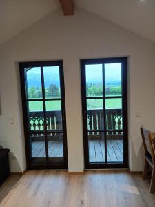 2 Türen in einem Zimmer mit Blick auf einen Balkon in der Unterkunft Wohnung Staufenblick in Freilassing