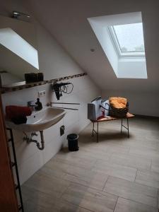 ein Bad im Dachgeschoss mit einem Waschbecken und einem Dachfenster in der Unterkunft Wohnung Staufenblick in Freilassing