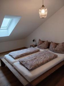 2 Betten in einem Schlafzimmer mit Dachfenster in der Unterkunft Wohnung Staufenblick in Freilassing