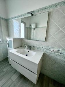 Baño blanco con lavabo y espejo en Sunset Street - La residenza del centro en Arborea 