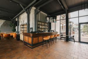 a bar with stools in a room with windows at Arcadia Plaza Hotel in Odesa