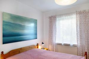 een slaapkamer met een bed en een groot schilderij aan de muur bij Ferienwohnung 'alte Schule' in Nienhagen