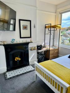 1 dormitorio con 1 cama y chimenea en Pierremont En-Suite Rooms en Broadstairs
