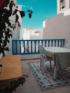 einen Tisch und einen Stuhl auf einem Balkon mit Meerblick in der Unterkunft Maison Albatros in Mahdia