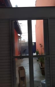 uma porta de vidro aberta com vista para um quintal em CasacentrocompartilhadaMogidasCruzes em Mogi das Cruzes