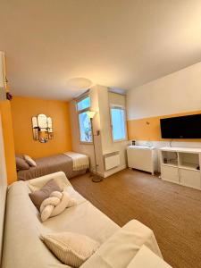 a large room with two beds and a flat screen tv at Appartement Cosy sur la Prestigieuse rue Faidherbe, à deux pas de la gare Lille Flandre in Lille