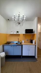 a kitchen with a sink and a chandelier at Appartement Cosy sur la Prestigieuse rue Faidherbe, à deux pas de la gare Lille Flandre in Lille