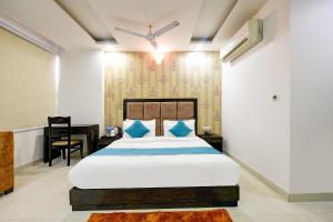 ocaen Suites Near Delhi Airport في نيودلهي: غرفة نوم بسرير كبير ومكتب