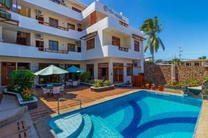 a hotel with a swimming pool in front of a building at Hotel Villa Laguna in Puerto Ayora