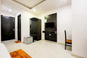 ocaen Suites Near Delhi Airport في نيودلهي: غرفة معيشة مع تلفزيون وأريكة