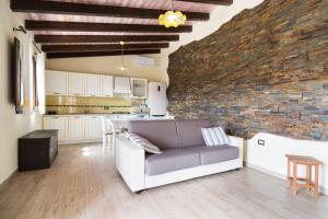 a living room with a couch and a brick wall at casa Luna in Dorgali