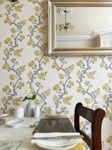 エディンバラにあるグラッドストーン ハウスのダイニングテーブル(壁に黄色い花を飾ったテーブル付)