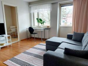 a living room with a couch and a table and a window at Spacious studio apartment near the center of Joensuu in Joensuu