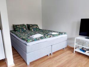 a small bed in a room with a tv at Spacious studio apartment near the center of Joensuu in Joensuu
