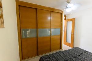 a large wooden closet in a bedroom with a bed at Los Hibiscos 406 in Costa Calma