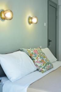 un letto con due cuscini e due luci sul muro di Greekowl apartments a Città di Skiathos