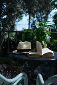 un cappello e un libro su un tavolo con una pianta di Greekowl apartments a Città di Skiathos