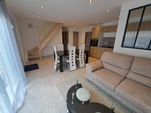 un salon avec un canapé et une table dans l'établissement Gites des falaises de Longues 6personnes, à Longues-sur-Mer