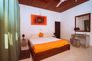 a bedroom with a bed and a painting on the wall at The Koarale Bungalow in Matara
