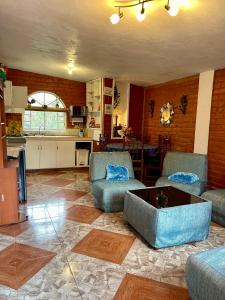 ein Wohnzimmer mit 2 Stühlen und einem Couchtisch in der Unterkunft Sinestesia House in Baños