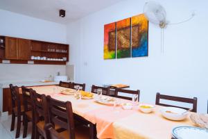 a dining room with a table with chairs and a painting at The Koarale Bungalow in Matara