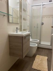 a bathroom with a sink and a toilet and a mirror at Casa Leonardo in Castiglione della Pescaia
