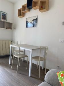 uma mesa de jantar branca e cadeiras num quarto em Casa Leonardo em Castiglione della Pescaia