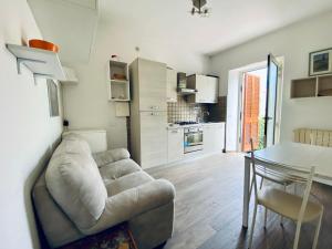 a living room with a couch and a table and a kitchen at Casa Leonardo in Castiglione della Pescaia
