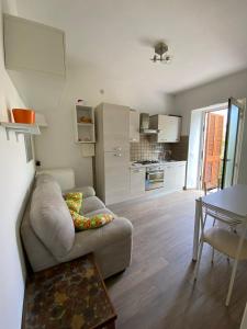 a living room with a couch and a kitchen at Casa Leonardo in Castiglione della Pescaia