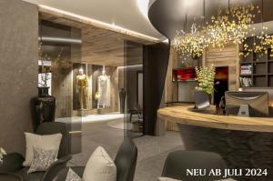 a lobby with a bar with chairs and a chandelier at Hotel Sonne Ischgl in Ischgl
