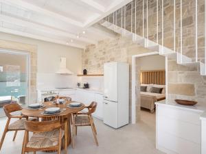 a kitchen and dining room with a table and a refrigerator at Pietra Di Sabbia Villas in Palaiochora