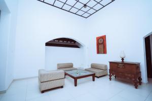 a living room with a couch and a table and a clock at The Koarale Bungalow in Matara
