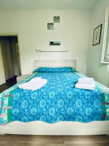 a bedroom with a blue bed with towels on it at Casa Leonardo in Castiglione della Pescaia