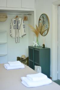 una stanza con tavolo, asciugamani e specchio di Greekowl apartments a Città di Skiathos