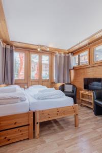 Duas camas num quarto com uma televisão e um sofá em Studio dans le plus beau village de Suisse em Grimentz