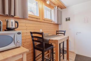 uma cozinha com uma mesa com cadeiras e um micro-ondas em Studio dans le plus beau village de Suisse em Grimentz