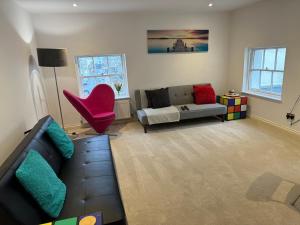salon z kanapą i czerwonym krzesłem w obiekcie Russell square Apartment 4 city w Brighton and Hove