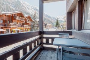 uma varanda com uma mesa e vista para uma montanha em Studio dans le plus beau village de Suisse em Grimentz
