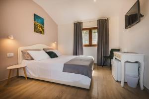 1 dormitorio con cama blanca y escritorio en Rooms with Breakfast near Porec, en Nova Vas